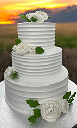 White Wedding Cake with White Flowers and Green Leaves